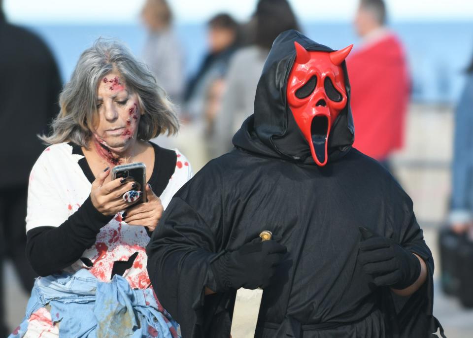 Participants are shown walking the boardwalk at the 2022 Asbury Park Zombie Walk