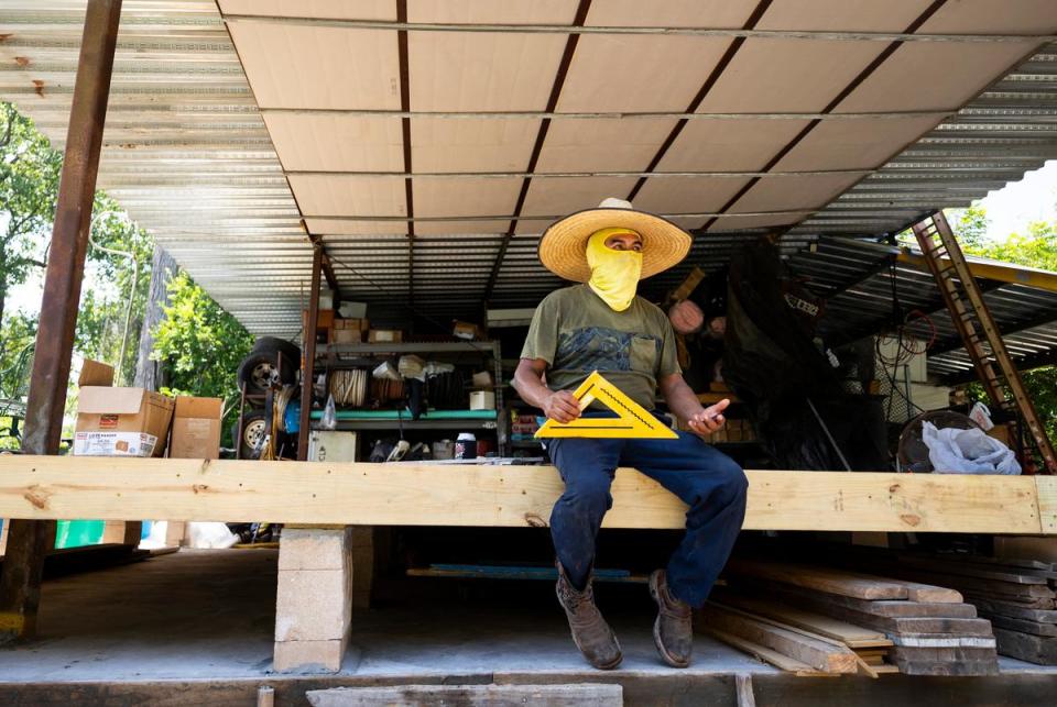Hector Torres Vasquez works on his property located in New River Lake Estates on June 28, 2023. Vasquez bought his property in in 2019 to relocate his auto shop and hadn’t heard of the buyout program for homeowners.