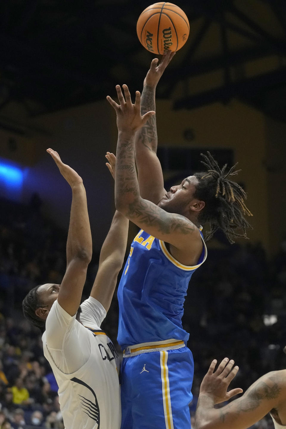 UCLA guard Brandon Williams, right, shoots against California forward Grant Newell during the second half of an NCAA college basketball game in Berkeley, Calif., Saturday, Feb. 10, 2024. (AP Photo/Jeff Chiu)