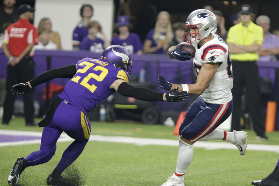 New England Patriots tight end Hunter Henry, right, breaks a tackle by Minnesota Vikings safety Harrison Smith (22) during a 37-yard touchdown reception in the second half of an NFL football game, Thursday, Nov. 24, 2022, in Minneapolis. (AP Photo/Andy Clayton-King)