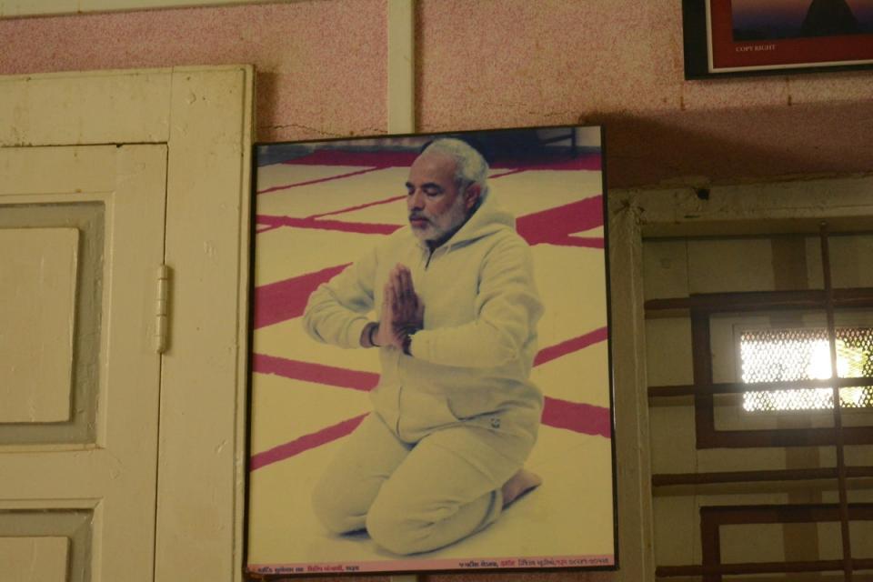 A framed picture of Narendra Modi on the wall of his brother Somabhai’s dimly lit and sparsely furnished office in Vadnagar (Namita Singh/The Independent)