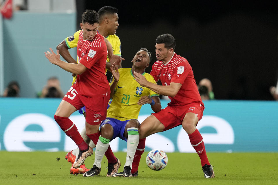 Los suizos Fabian Rieder (izquierda) y Remo Freuler marcan al brasileño Rodrygo durante el partido por el Grupo G del Mundial, el lunes 28 de noviembre de 2022, en Doha, Qatar. (AP Foto/Natacha Pisarenko)