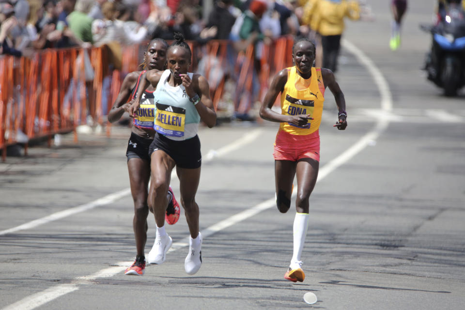 Kenya's Hellen Obiri, center, surges ahead of Sharon Lodeki, left, and Edna Kiplagat, right, just past mile 23 in Brookline, Mass., during the Boston Marathon, Monday April 15, 2024. Obiri won the women's division. (AP Photo/Jennifer McDermott)