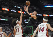 Boston Celtics center Kristaps Porzingis (8) aims to score as Miami Heat guard Jaime Jaquez Jr. (11) defends during the first half of Game 4 of an NBA basketball first-round playoff series Monday, April 29, 2024, in Miami. (AP Photo/Marta Lavandier)