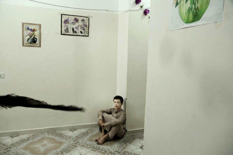 In this July 25, 2018, photo, 14 year-old Abdel Majeed sits on the floor at a rehabilitation center for former child soldiers in Marib, Yemen. Nearly 200 former child soldiers have come through the Saudi-funded center, where they try to learn how to deal with the traumas and horrors they saw in combat. (AP Photo/Nariman El-Mofty)