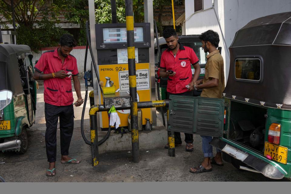 Workers fill gas in vehicles at a fuel station in Colombo, Sri Lanka, Wednesday, March 29, 2023. Sri Lanka’s government has announced reduction in fuel prices, the first significant relief to the public after a year of shortages and skyrocketing prices amid the country’s worst economic crisis. (AP Photo/Eranga Jayawardena)