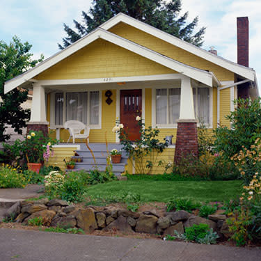 Yellow-bungalow-style-house-with-garden-exterior-view_web