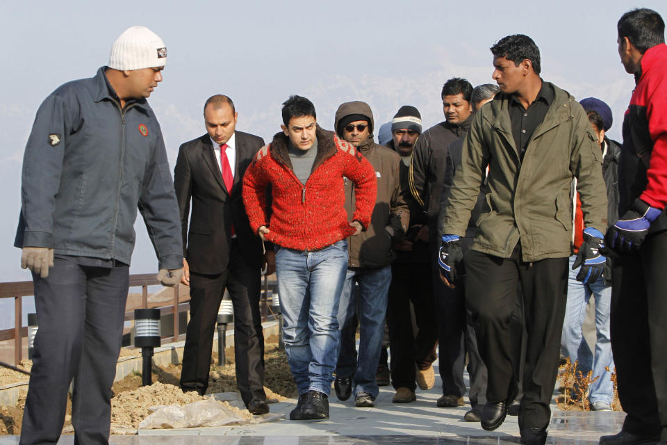 FILE-In this Feb. 9, 2012 file photo, Bollywood actor Aamir Khan, third left, arrives at his hotel in Srinagar, Kashmir, India. Bollywood megastar Khan is making India confront its dark side. Shining light on inequities like the rampant abortion of female fetuses, caste discrimination and the slaying of brides in dowry disputes, actor Khan has reached an estimated one-third of the country with a new TV talk show "Satyamev Jayate", or "Truth Alone Prevails," that tackles persistent flaws of modern India that most of its citizens would prefer to ignore.(AP Photo/Javed Ahmad, File)