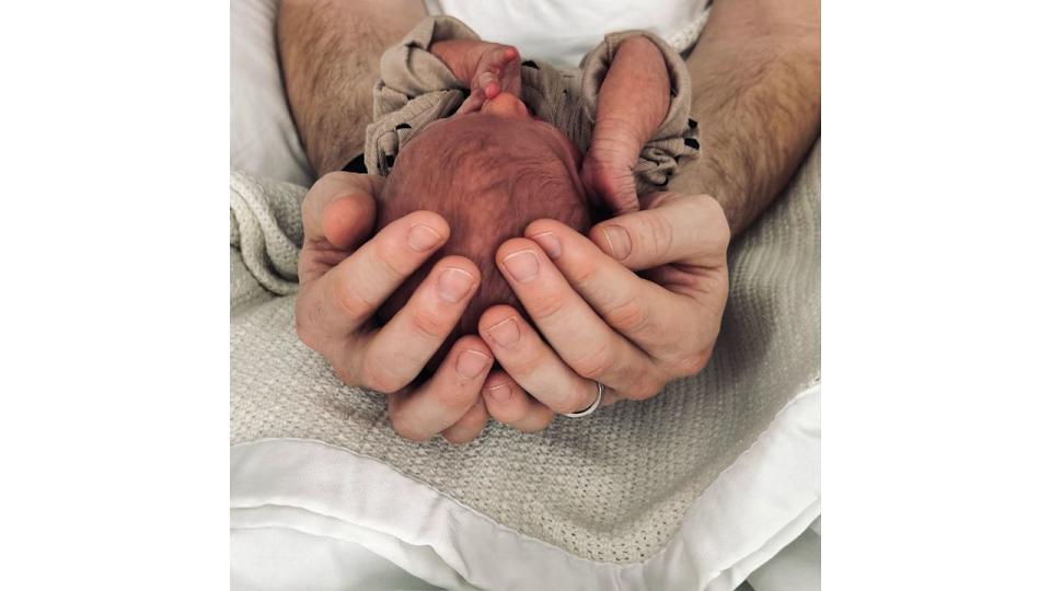 Olly Murs cradling his newborn baby