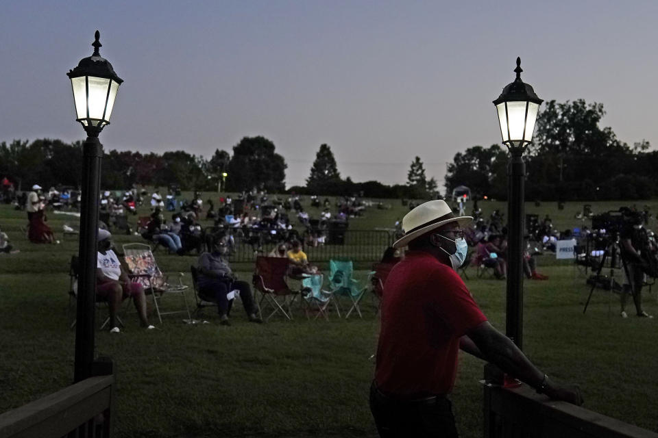 A man watches the Black Panther movie during a Chadwick Boseman Tribute on Thursday, Sept. 3, 2020, in Anderson, S.C. (AP Photo/Brynn Anderson)