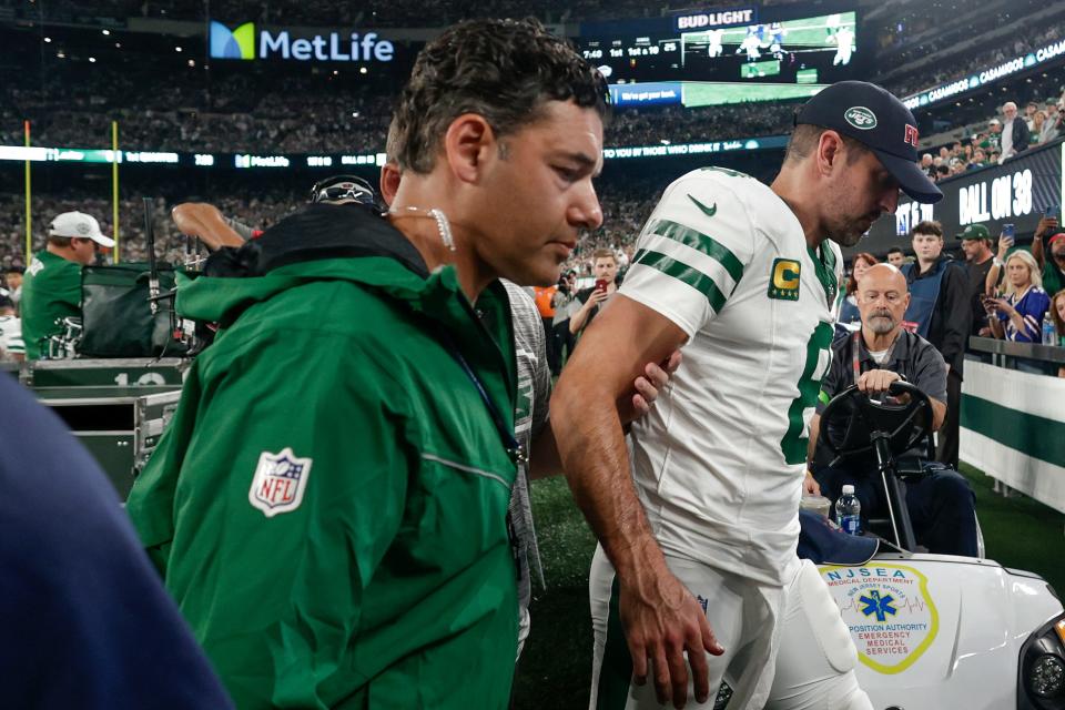 New York Jets quarterback Aaron Rodgers (8) is helped off the field during the first quarter of an NFL football game against the Buffalo Bills, Monday, Sept. 11, 2023, in East Rutherford, N.J. (AP Photo/Adam Hunger)