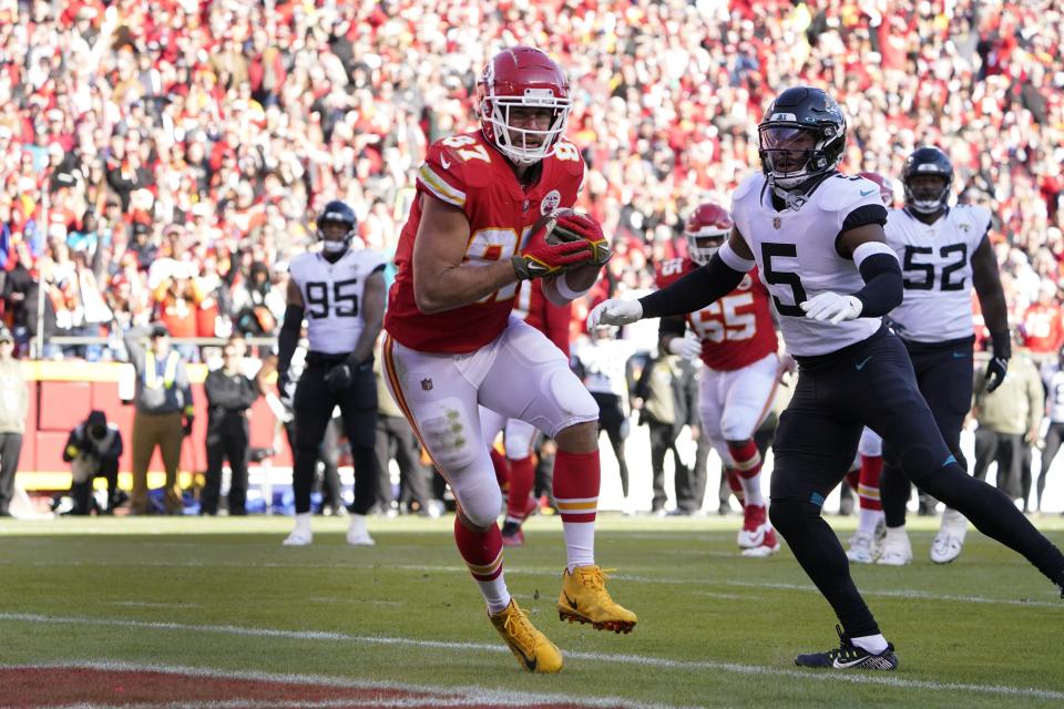 Kansas City Chiefs tight end Travis Kelce (87) catches a touchdown pass as Jacksonville Jaguars safety Andre Cisco (5) defends during the second half of an NFL football game Sunday, Nov. 13, 2022, in Kansas City, Mo. (AP Photo/Ed Zurga)