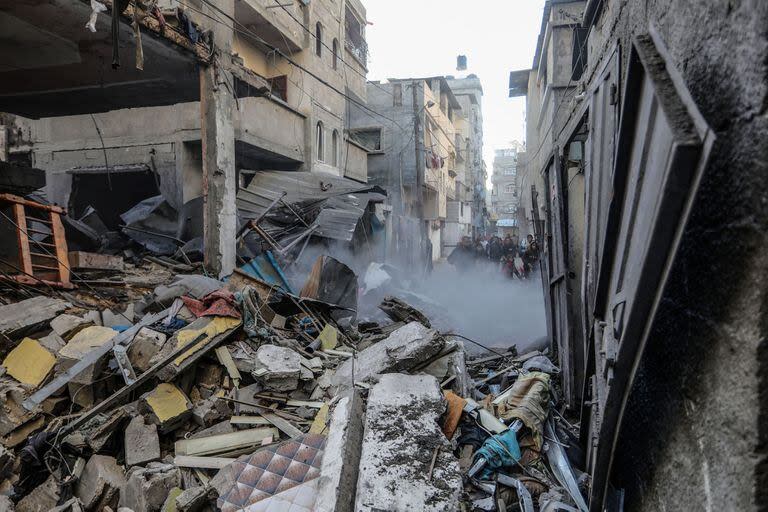 Los palestinos inspeccionan un edificio destruido perteneciente a la familia Abu Al-Awf después de un ataque aéreo israelí contra Rafah, en el sur de la Franja de Gaza.