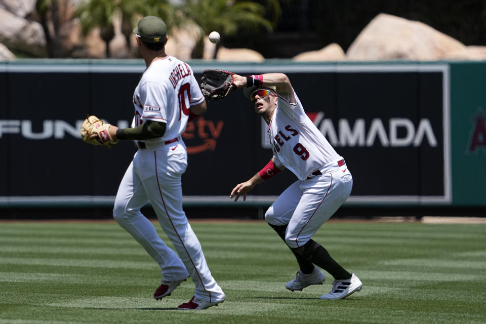 Los Angeles Angels shortstop Zach Neto, left, makes a catch on a ball hit by Minnesota Twins' Trevor Larnach as third baseman Gio Urshela watches during the second inning of a baseball game Sunday, May 21, 2023, in Anaheim, Calif. (AP Photo/Mark J. Terrill)