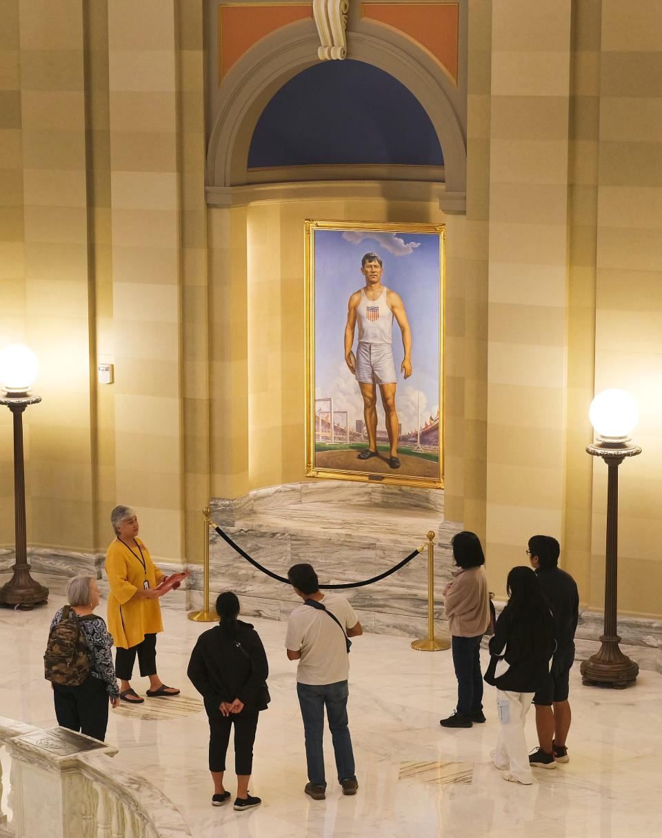 A tour guide talks about the painting of Jim Thorpe on the fourth floor at the Oklahoma Capitol Thursday, Oct. 5, 2023.