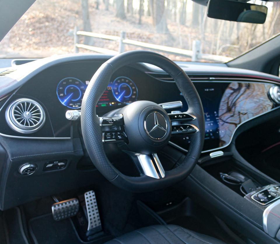 The 2023 Mercedes-Benz EQS SUV's steering wheel, with a digital gauge cluster seen in the background.