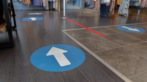 Arrows directing customers around the store space are one of the protective measures at Boutique Moi in Gatineau, Que., May 16, 2021, the day before it was allowed to reopen for in-person shopping under relaxed provincial rules.