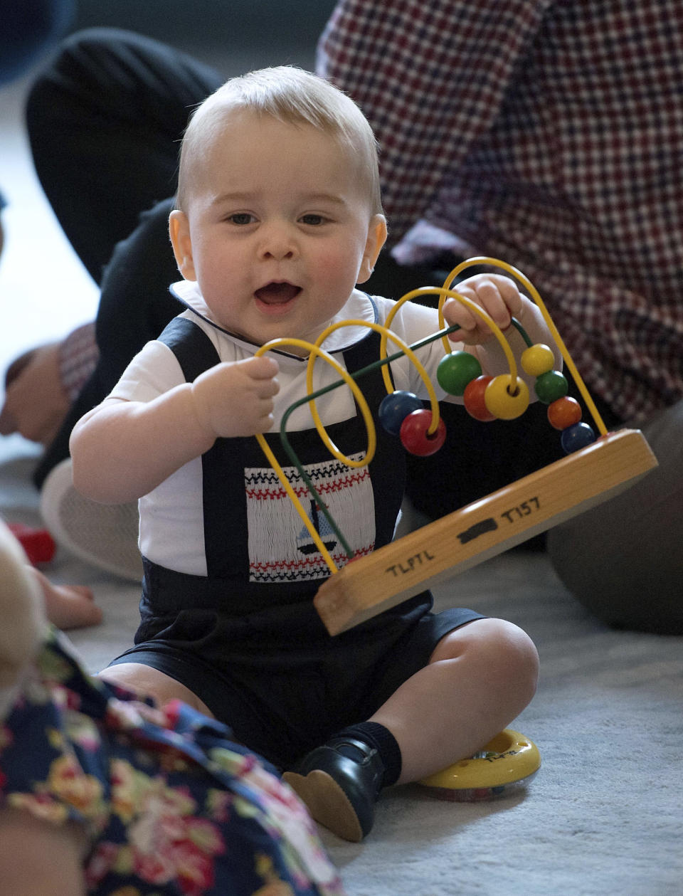 Britain's Prince George plays during a visit to Plunket nurse and parents group at Government House in Wellington, New Zealand, Wednesday, April 9, 2014. Plunket is a national not-for-profit organization that provides care for children and families in New Zealand. Britain's Prince William, his wife Kate, the Duchess of Cambridge and their son, Prince George, are on a three-week tour of New Zealand and Australia. (AP Photo/Marty Melville, Pool)