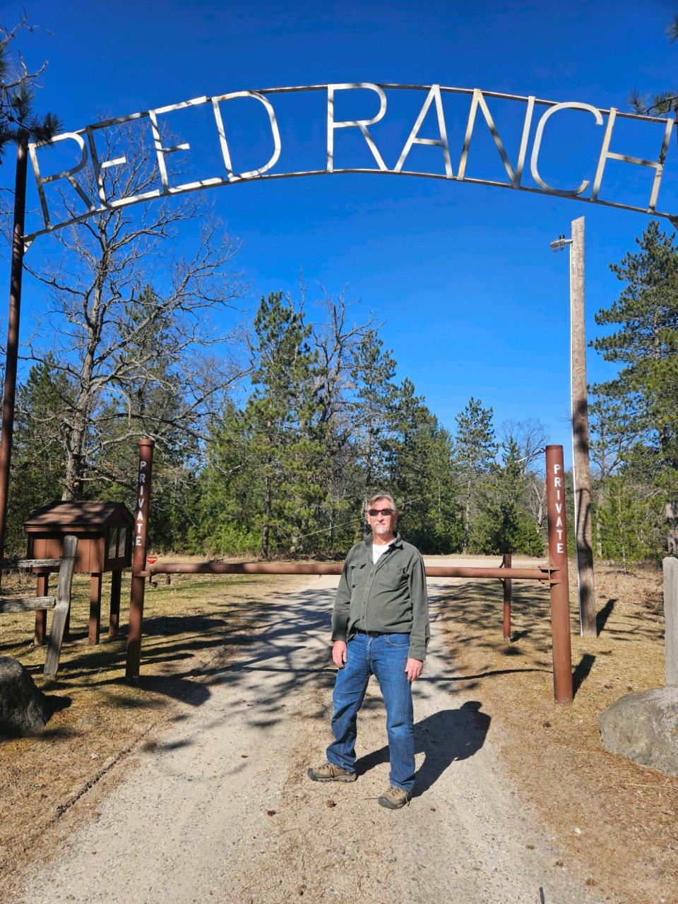 Nick Socia, former Reed Ranch manager, standing at the gate of Reed Ranch in Oscoda County, Michigan.