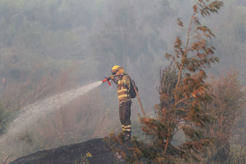 A firefighter works during a wildfire at the 'Santa Rosa de Colmo' area, in Valparaiso
