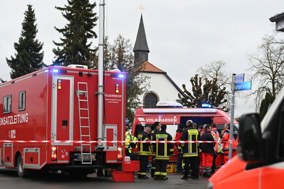 Police and rescue workers stand next to the scene of the crash in Volkmarsen (AP)