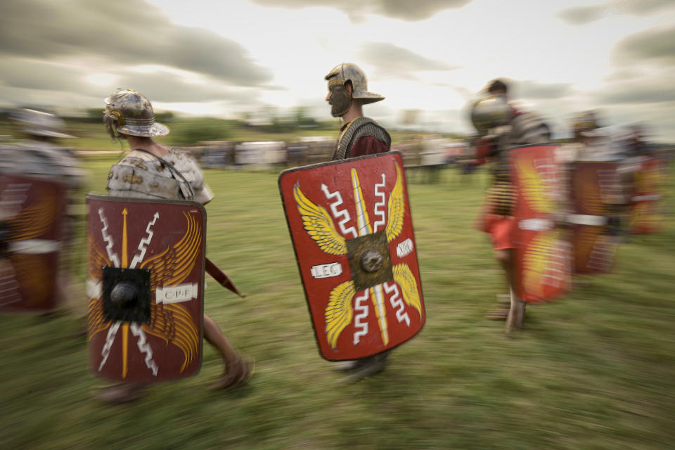 Men wearing Roman soldier outfits walk during a battle at the Romula Fest historic reenactment festival in the village of Resca, Romania, Sunday, Sept. 4, 2022. (AP Photo/Andreea Alexandru)