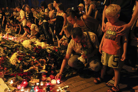 People place candles and flowers at the Dutch embassy to commemorate the victims of Malaysia Airlines MH17, which crashed in eastern Ukraine, in Kiev July 17, 2014. REUTERS/Valentyn Ogirenko