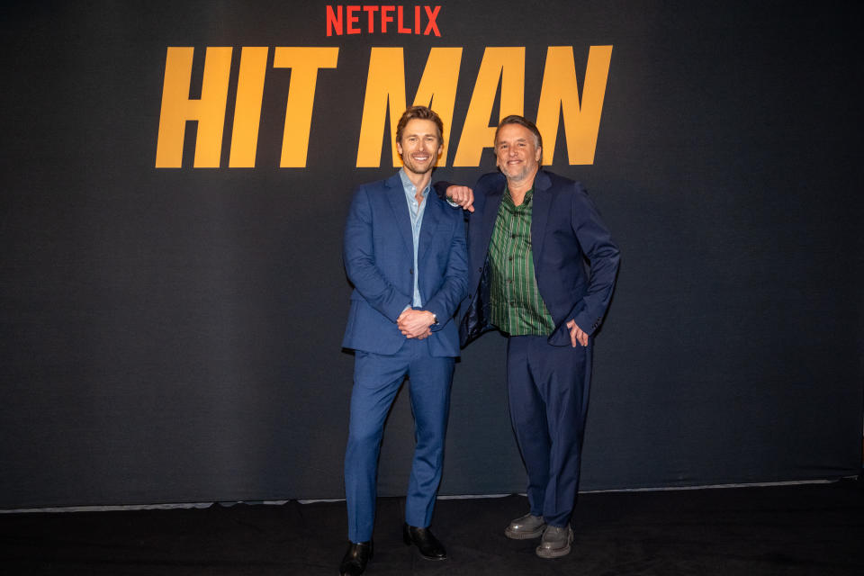 Glen Powell and Richard Linklater pose together on the red carpet at the Netflix "Hit Man" event.