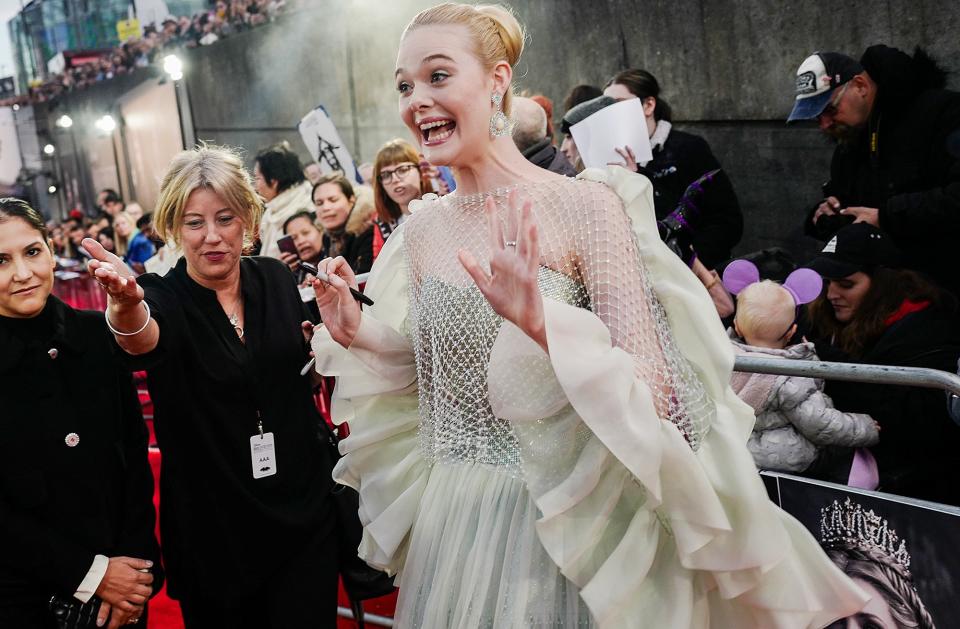 An all-dressed-up Elle Fanning greets fans on Wednesday at the London premiere of <em>Maleficent: Mistress of Evil.</em>