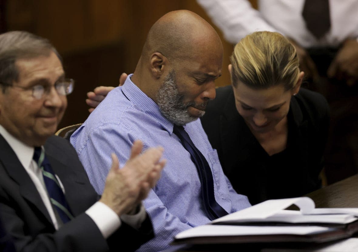 Lamar Johnson, center and his attorneys react on Tuesday, Feb. 14, 2023, after St. Louis Circuit Judge David Mason vacated his murder conviction during a hearing in St. Louis, Mo. (Christian Gooden/St. Louis Post-Dispatch via AP, Pool)