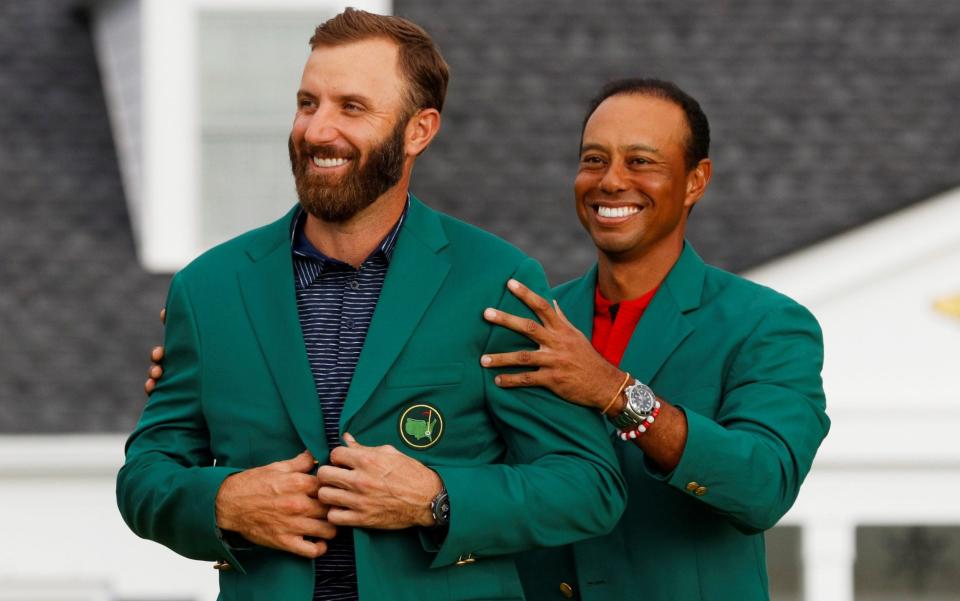 Dustin Johnson of the U.S. is presented with the green jacket by Tiger Woods - Reuters