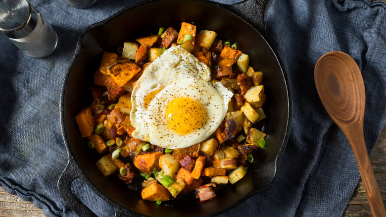 a pan of sweet potato hash with eggs