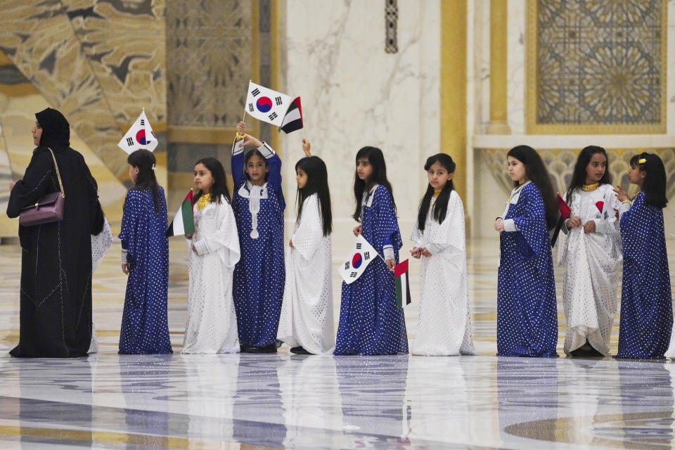 Emirati school girls prepare to greet South Korean President Yoon Suk Yeol at Qasar Al Watan in Abu Dhabi, United Arab Emirates, Sunday, Jan. 15, 2023. South Korean President Yoon Suk Yeol received an honor guard welcome Sunday on a trip to the United Arab Emirates, where Seoul hopes to expand its military sales while finishing its construction of the Arabian Peninsula's first nuclear power plant. (AP Photo/Jon Gambrell)