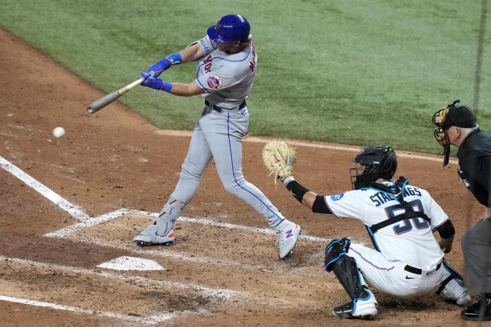 New York Mets'  Jeff McNeil, left, hits a single to score Starling Marte during the sixth inning of an opening day baseball game against the Miami Marlins, Thursday, March 30, 2023, in Miami.  (AP Photo/Lynne Sladky)