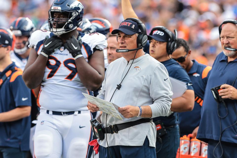 Vic Fangio wears an FDNY hat on the sideline while coaching the Denver Bronocs during a game against the New York Giants.