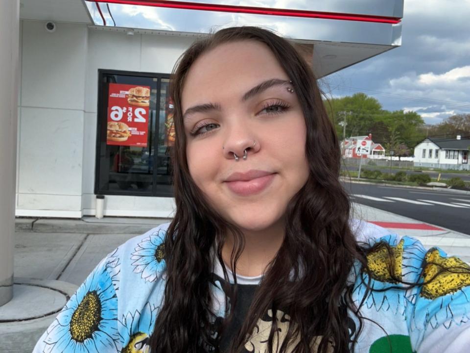 amena posing in front of a checkers location