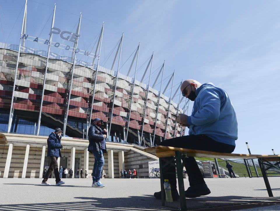 People leave a vaccination center at the National Stadium that also houses a temporary COVID-19 hospital, in Warsaw, Poland, Friday, April 2, 2021, the day when Poland registered its all-time record number of new infections. Poland is speeding up the nationwide vaccination procedures and on Thursday opened registration for people aged 40-60. (AP Photo/Czarek Sokolowski)