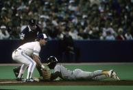 Outfielder Rickey Henderson of the Oakland Athletics dives into third base beating the tag of third baseman Kelly Gruber of the Toronto Blue Jay during an early circa 1990's Major League baseball game at the SkyDome. (Photo by Focus on Sport/Getty Images)