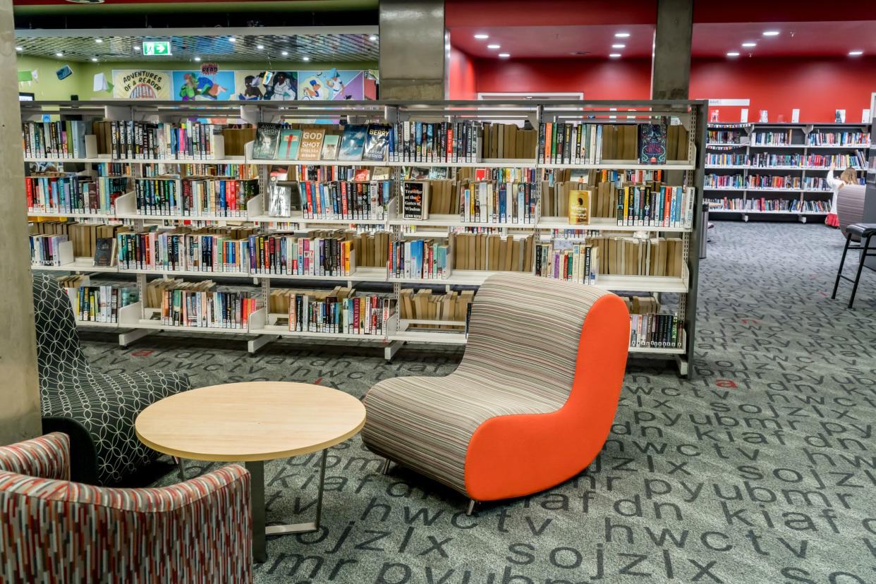 Sydney, Australia - 2022-01-25 At the community public local library. Chairs waiting for readers and bookshelfs full of books. Cronulla Library, NSW.