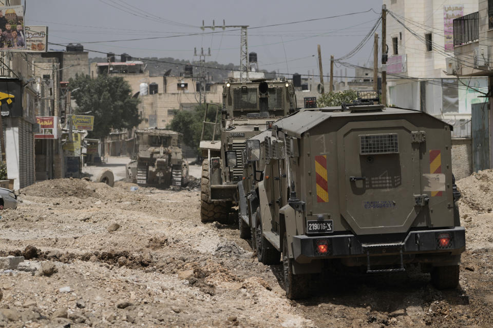 Israeli military vehicles are seen during a raid in the West Bank Jenin refugee camp, Tuesday, May 21, 2024. Israeli forces raided a militant stronghold Tuesday in the occupied West Bank, killing at least seven and wounding several, according to the Palestinian Health Ministry. The raid into the Jenin refugee camp is part of months of surging violence in the Palestinian territory. (AP Photo/Majdi Mohammed)