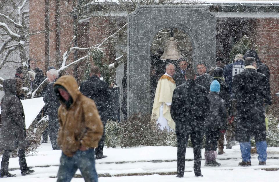 People gather following mass at St. Rose church as a permanent memorial is dedicated to the victims of the Sandy Hook Elementary School shooting in Newtown, Connecticut December 14, 2013 . Today marks the one year anniversary of the shooting rampage at Sandy Hook Elementary School, where 20 children and six adults were killed by gunman Adam Lanza. (REUTERS/Michelle McLoughlin)