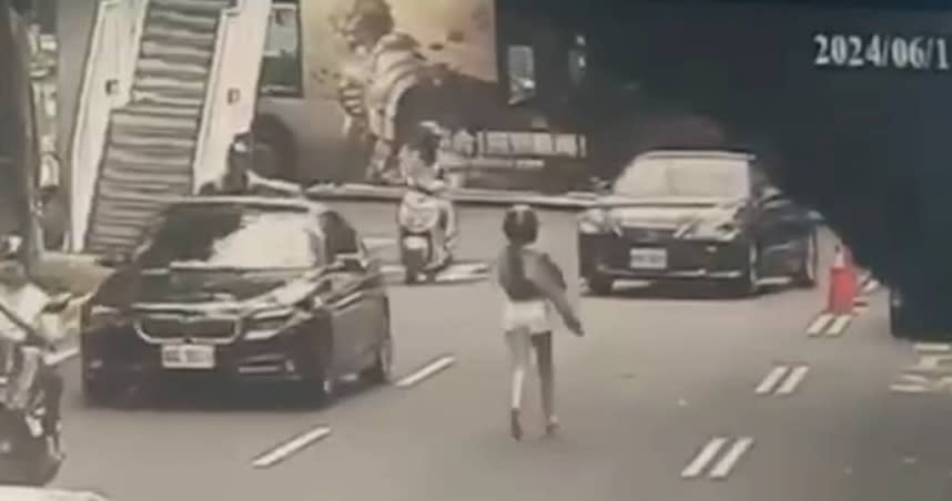 穿著熱褲的女子手機掉落快車道，竟不顧自身安全，衝上車道撿拾。（圖／翻攝畫面）