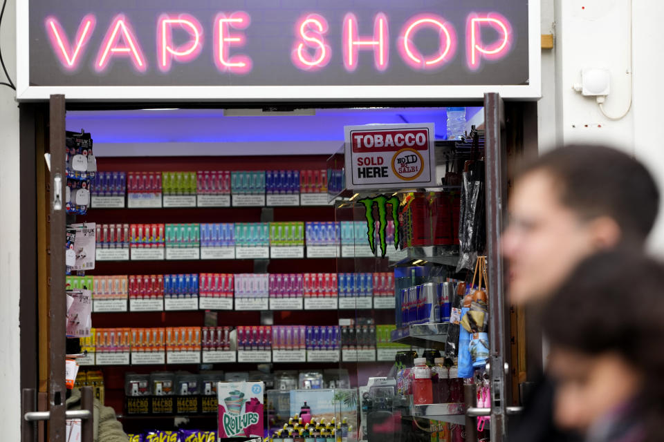 Pedestrians pass a vape shop in London, Monday, Jan. 29, 2024. The British government says it will ban the sale of disposable vapes and limit their cornucopia of flavors in an effort to prevent children becoming addicted to nicotine. It also says it will stick to a contentious proposal to ban today's young people from ever buying cigarettes. (AP Photo/Kirsty Wigglesworth)