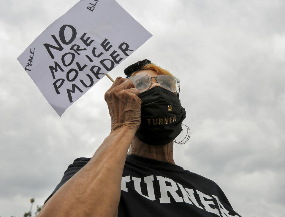 Linda Magwood holds up a sign as she listens to speakers during a "Justice for Pamela Turner" rally on the two-year-anniversary of Turner's death, Thursday, May 13, 2021, in Baytown, Texas. Turner was fatally shot in 2019 by a police officer in the Houston suburb after a struggle over his stun gun. (Godofredo A. Vásquez/Houston Chronicle via AP)