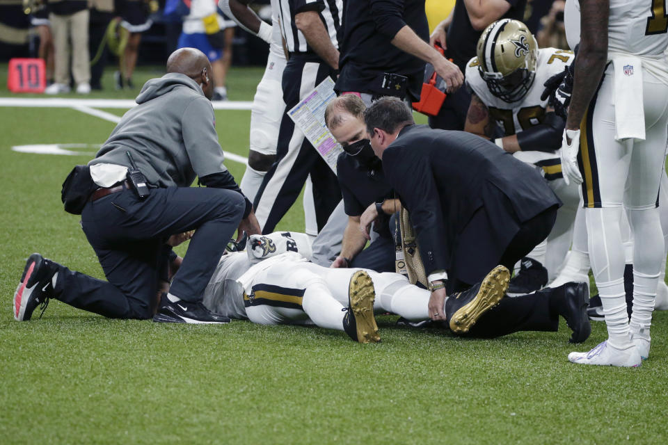 New Orleans Saints quarterback Jameis Winston is tended to after being injured from a horse collar tackle in the first half of an NFL football game against the Tampa Bay Buccaneers in New Orleans, Sunday, Oct. 31, 2021. (AP Photo/Butch Dill)