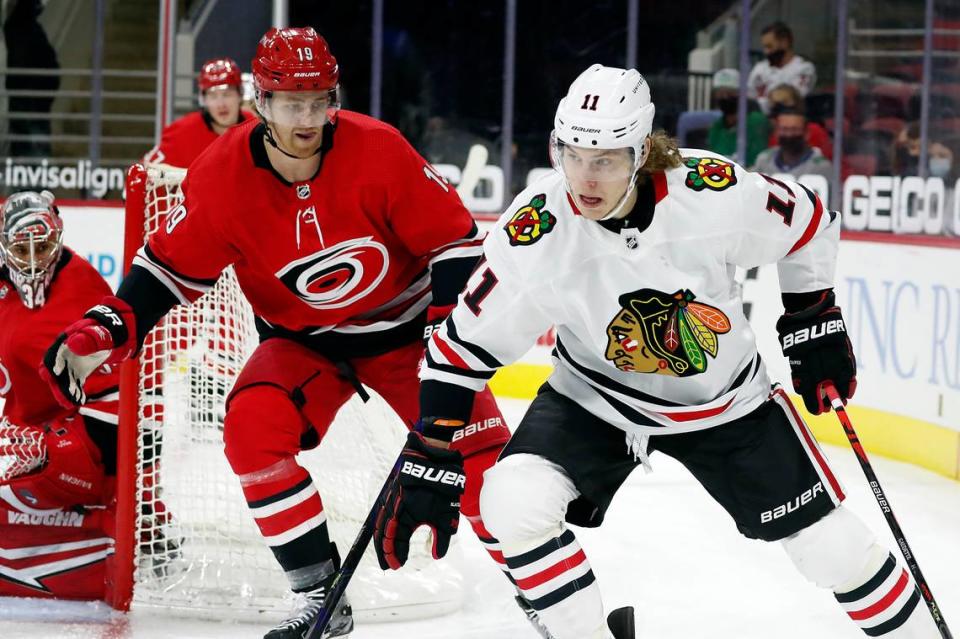 Chicago Blackhawks’ Adam Gaudette (11) drives the puck around Carolina Hurricanes’ Dougie Hamilton (19) during the first period of an NHL hockey game in Raleigh, N.C., Thursday, May 6, 2021. (AP Photo/Karl B DeBlaker)