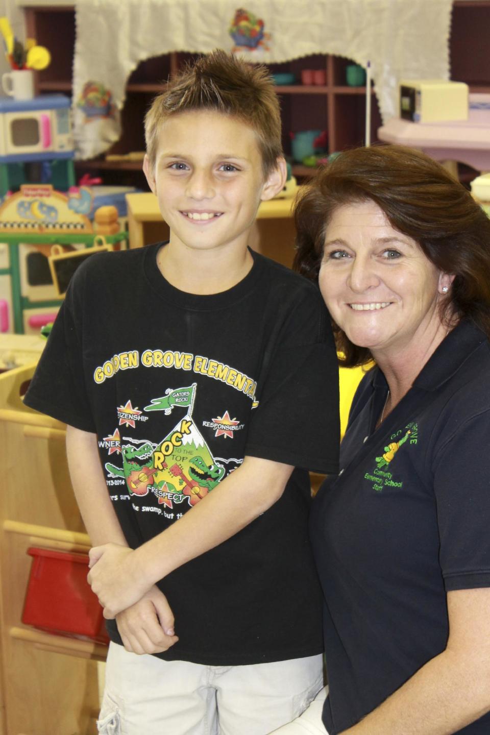 In this hand handout photo Matthew Palma poses for a photo with Stephanie Dana-Schmidt during a play therapy session at school in West Palm Beach, Fla., Friday, Nov. 1, 2013. Matthew attended play sessions as part of Primary Project, which screens 3,000 kindergarten and first-graders in Palm Beach County each year through a one-page assessment completed by teachers. Matthew’s mom says his confidence improved dramatically and the now fifth grader isn’t afraid to talk to adults or raise his hand in class. (AP Photo/Handout)