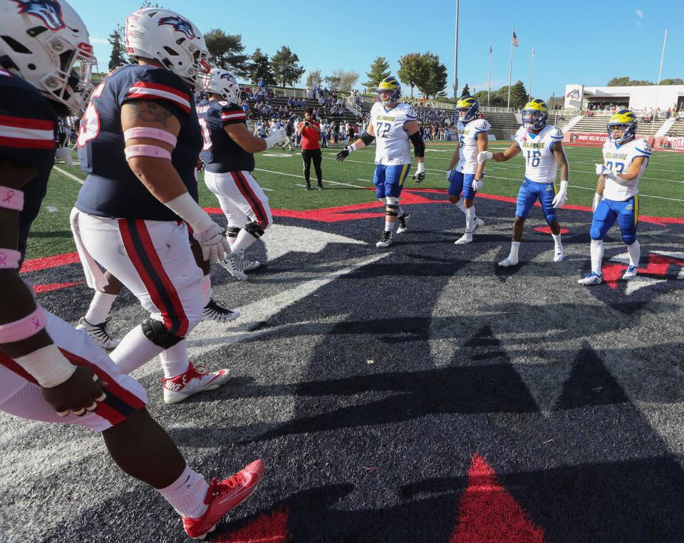 Delaware captains (from left) David Kroll, Gene Coleman II, Nijuel Hill and  Dejoun Lee greet their counterparts after the coin toss before the Blue Hens' 34-17 loss at Stony Brook, Saturday, Oct. 16, 2021.