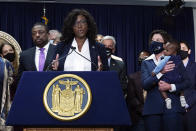 New York state Assembly member Phara Souffrant Forrest speaks, as New York Gov. Kathy Hochul, right, holds her son David, before Hochul signed the "Less is More" law, during ceremonies in the governor's office, in New York, Friday, Sept. 17, 2021. New Yorkers will be able to avoid jail time for most nonviolent parole violations under a new law that will take effect in March, and largely eliminates New York's practice of incarcerating people for technical parole violations. At left is Lt. Gov. Brian Benjamin. (AP Photo/Richard Drew)