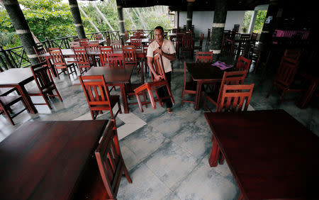 A man arranges chairs at an empty restaurant of the Warahena Beach hotel in Bentota, Sri Lanka May 2, 2019. REUTERS/Dinuka Liyanawatte